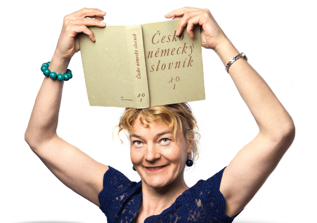 Žena držící si na hlavě česko-německý slovník